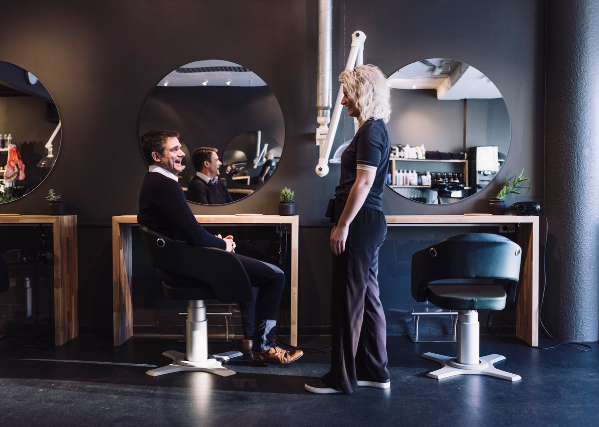 Hairdresser Lena Staddeland talking with a client in her salon in southern Norway