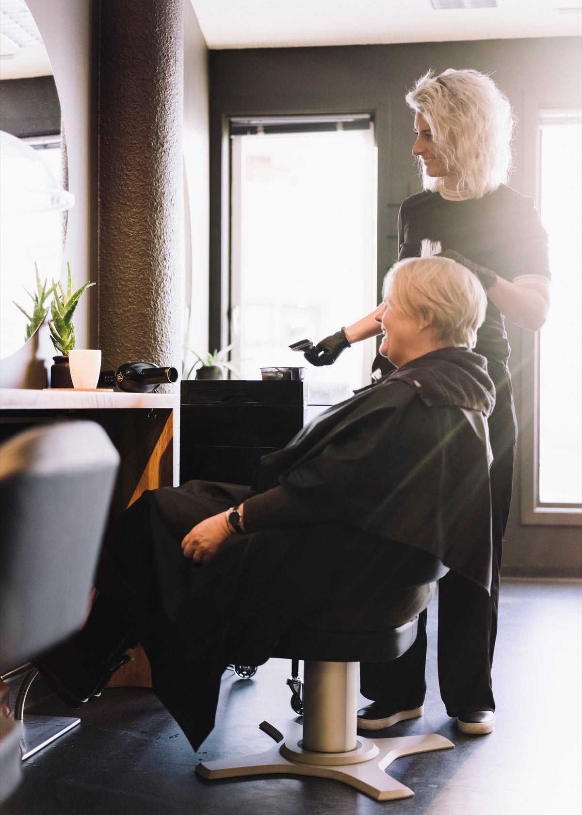 Lena Staddeland, founder of Sanasella, cutting hair with an ergonomic salon chair